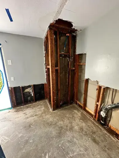 Wall opened at the bottom so the framing behind it can dry