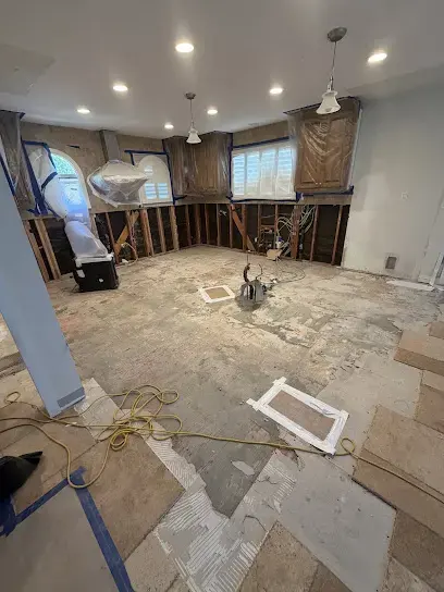 Room with the flooring pulled up to the subfloor while the drying equipment runs
