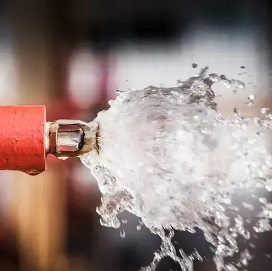 Water bursting out of a broken pipe end under full pressure, burst pipe water damage in Laguna Niguel