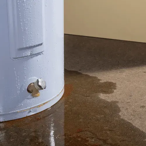 Water pooled on the floor around the base of a leaking tank water heater in Laguna Niguel